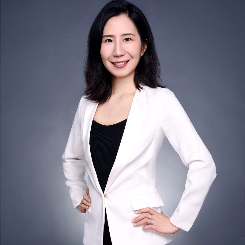 Headshot of Subrina Shen in a white jacket and black blouse.
