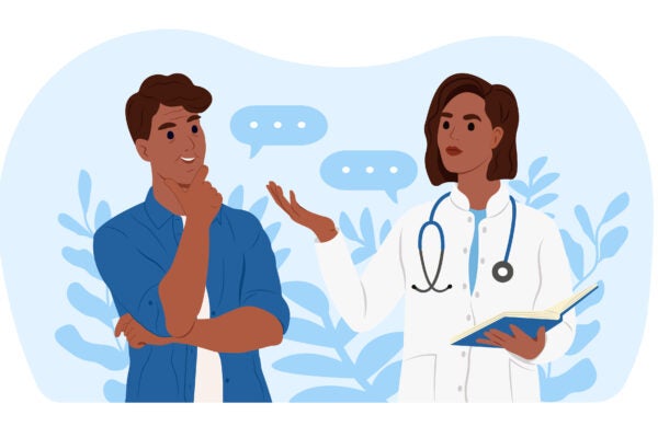 An African American female family doctor is talking to an elderly African American male patient.