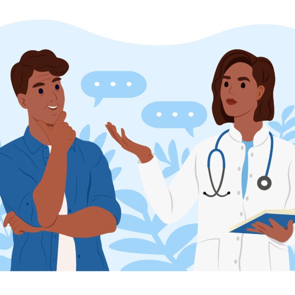 An African American female family doctor is talking to an elderly African American male patient.