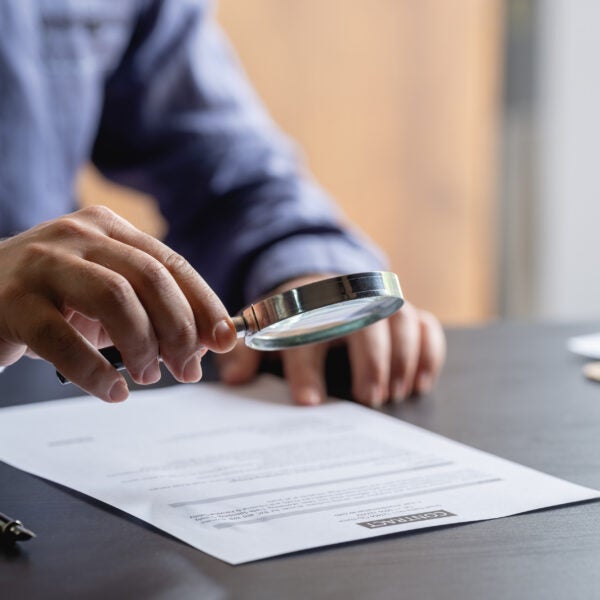 Businessman Signing Legal Paper In Office