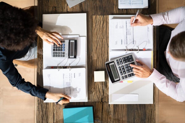 Two Business Colleagues Calculating Tax