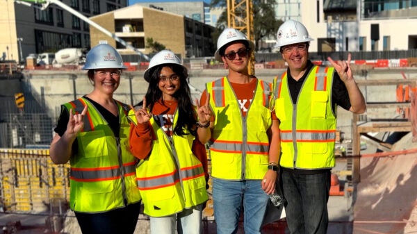 Members of McCombs leadership team pose with two first-year students in front of the Mulva Hall construction site Oct. 8. (Left to right) Caitlin Mullaney, senior associate dean for business affairs and chief operating officer; freshmen Varshini Byreddy and Diego Beyer; and Ty Henderson, associate dean for undergraduate programs.