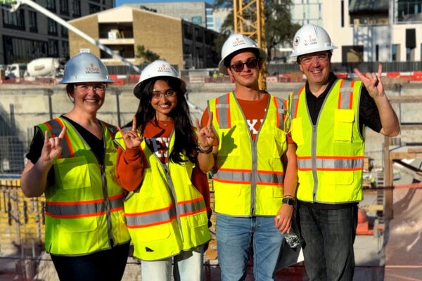 Members of McCombs leadership team pose with two first-year students in front of the Mulva Hall construction site Oct. 8. (Left to right) Caitlin Mullaney, senior associate dean for business affairs and chief operating officer; freshmen Varshini Byreddy and Diego Beyer; and Ty Henderson, associate dean for undergraduate programs.
